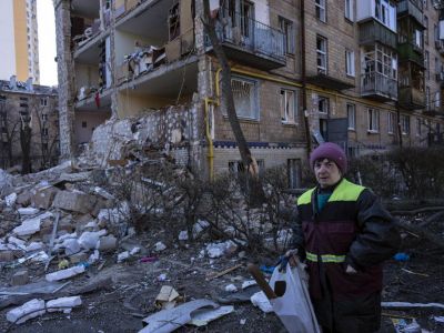 Женщина рядом с жилым домом, разрушенным в результате бомбардировки в Киеве 18 марта 2022 г. Фото: Rodrigo Abd / AP Photo